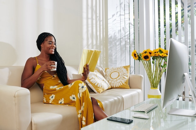 Donna che beve caffè e libro di lettura