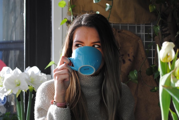 Donna che beve caffè nel cortile sul retro