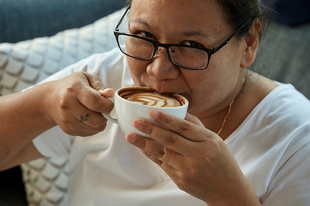 Donna che beve caffè nella caffetteria