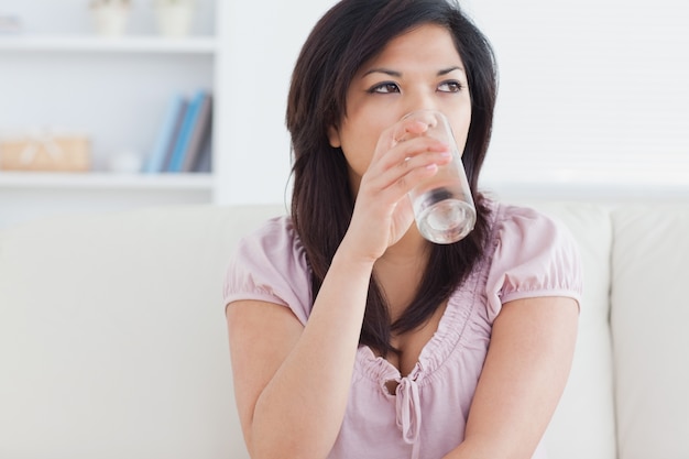 Donna che beve da un bicchiere d&#39;acqua