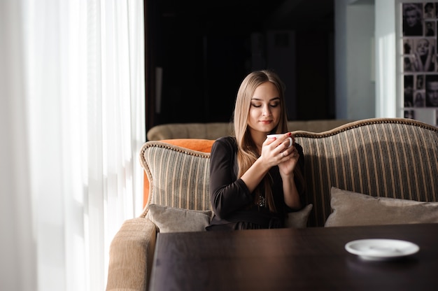 Donna che beve il caffè al mattino al ristorante.