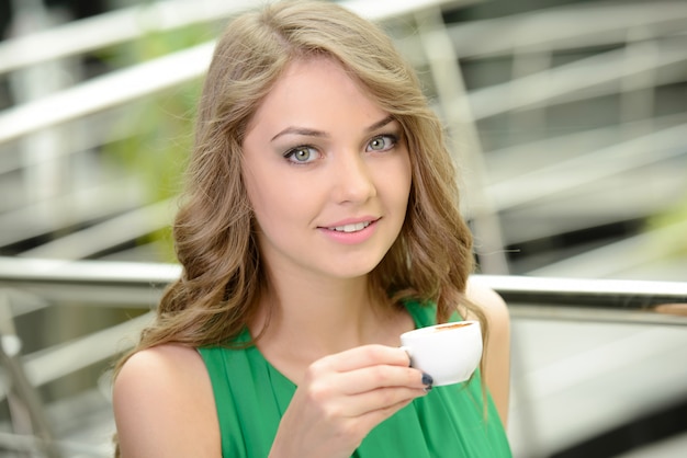 Donna che beve il caffè al mattino al ristorante.