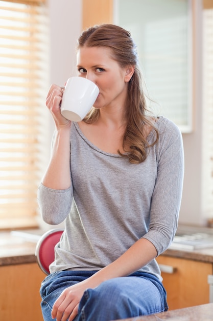 Donna che beve il caffè in cucina