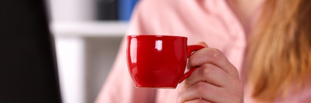 Donna che beve il tè in ufficio