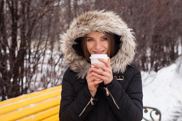 Donna che beve la sua bevanda calda dalla tazza Stagione invernale