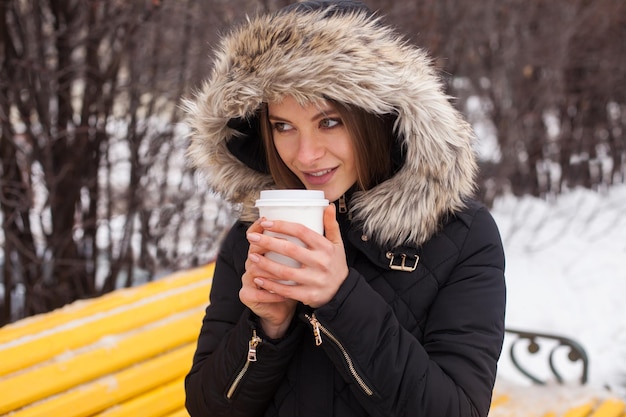 Donna che beve la sua bevanda calda dalla tazza Stagione invernale