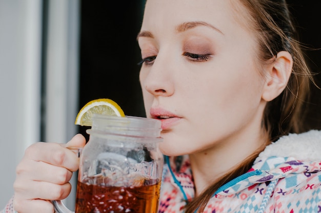 Donna che beve tè al limone