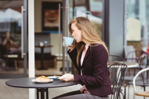 Donna che beve una tazza di caffè in caffè