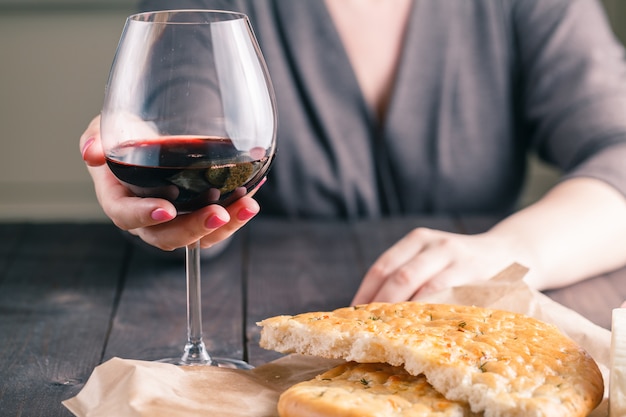 Donna che beve vino e mangia pane