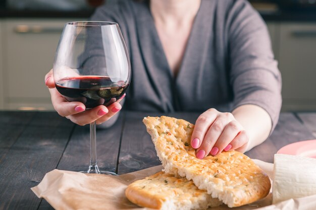 Donna che beve vino e mangia pane