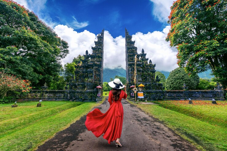 Donna che cammina al grande cancello dell'entrata, Bali in Indonesia.