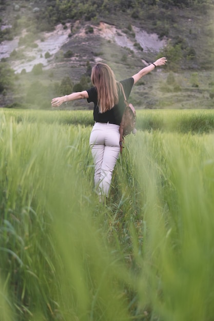 Donna che cammina attraverso i campi di grano