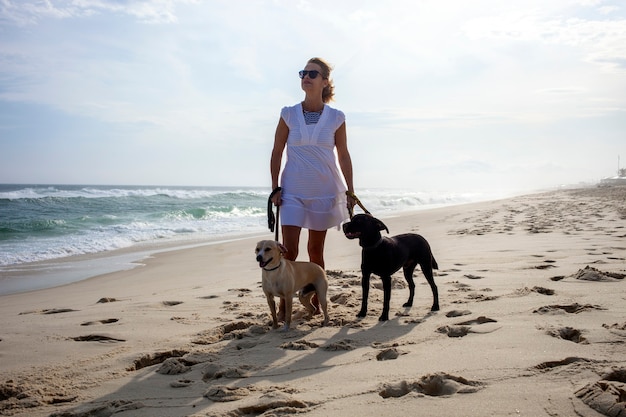 Donna che cammina con i cani sulla spiaggia, Barra da Tijuca Rio de Janeiro