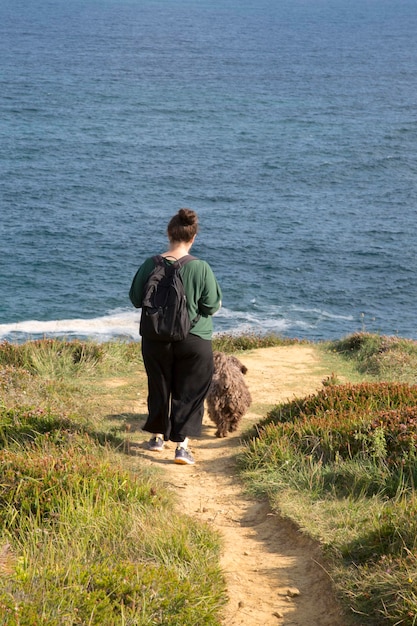 Donna che cammina con il cane a Loredo, Santander, Spagna