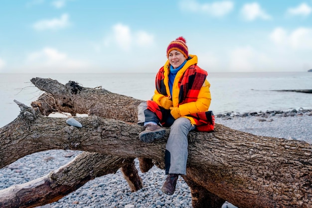 Donna che cammina da sola sul mare in una fredda giornata invernale Concetto di stile di vita di viaggio