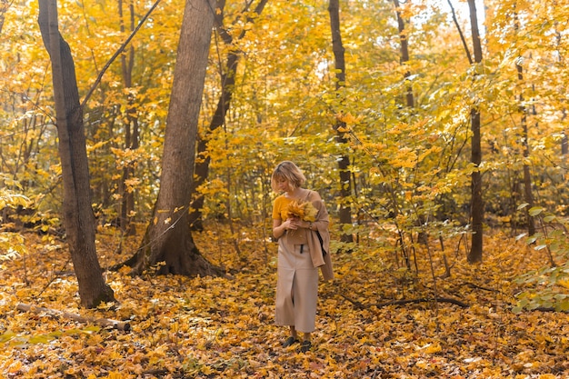 Donna che cammina in un giorno d'autunno nella bellissima stagione del parco autunnale e nel concetto di solitudine