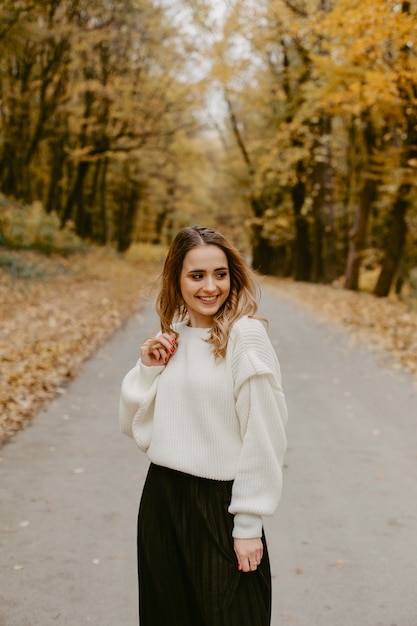 Donna che cammina nel parco d'autunno