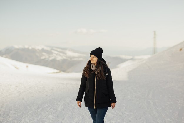 Donna che cammina sulla montagna innevata