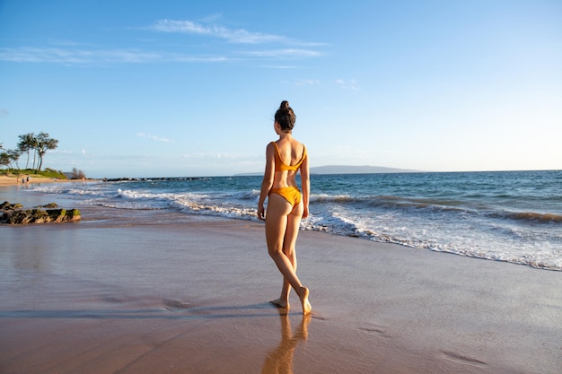 Donna che cammina sulla natura della riva del mare Meditazione divina calma attraverso la luce estiva Vista posteriore