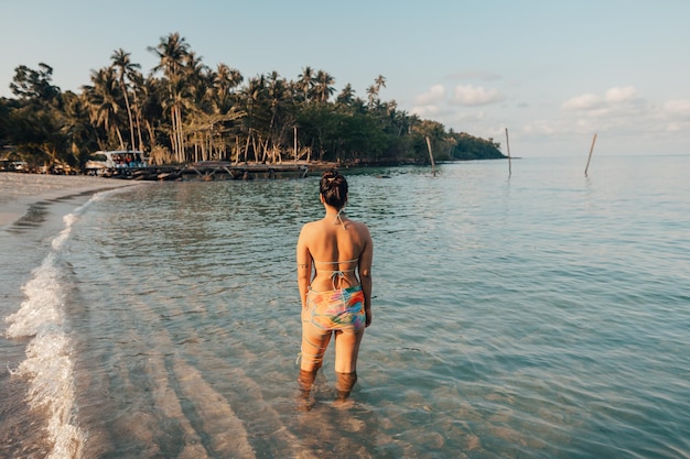 Donna che cammina sulla spiaggia al mattino