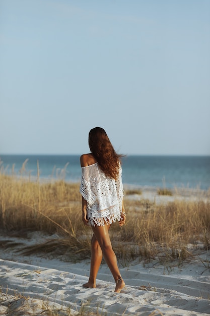Donna che cammina sulla spiaggia durante le vacanze