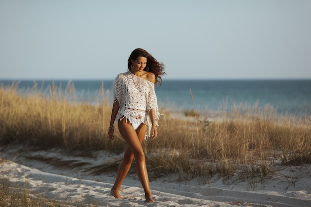 Donna che cammina sulla spiaggia durante le vacanze