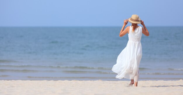 Donna che cammina sulla spiaggia tropicale