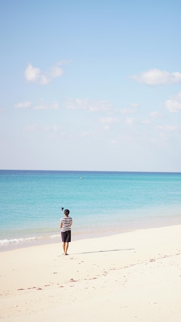 Donna che cammina sulla spiaggia