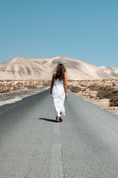 Donna che cammina sulla strada negli altopiani