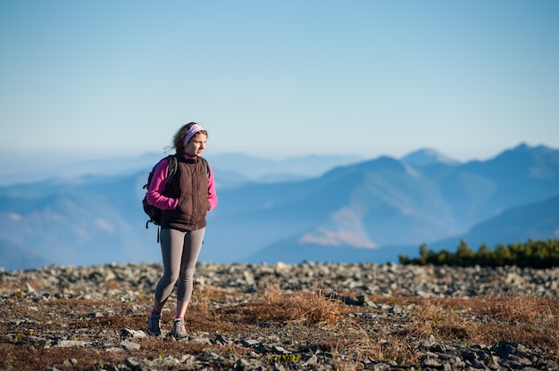 Donna che cammina sulle montagne rocciose che godono della natura