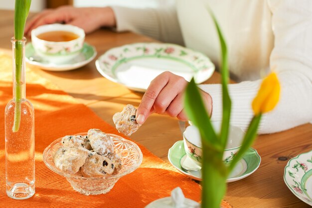 Donna che cattura i biscotti dal tavolino da salotto