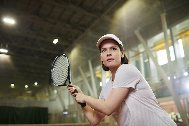 Donna che cattura la pallina da tennis con la racchetta