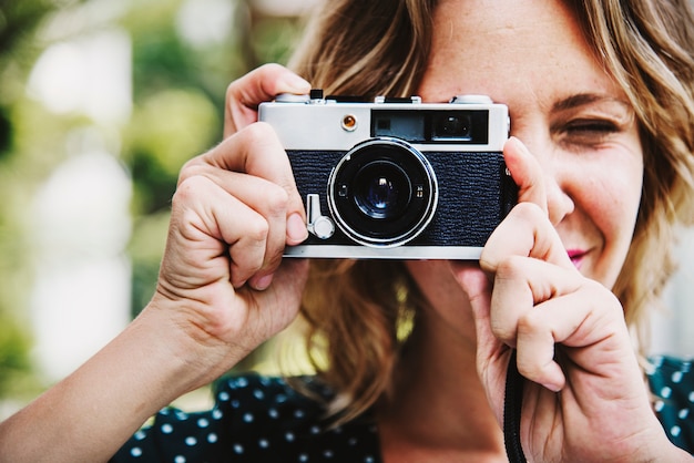 Donna che cattura maschera con la macchina fotografica