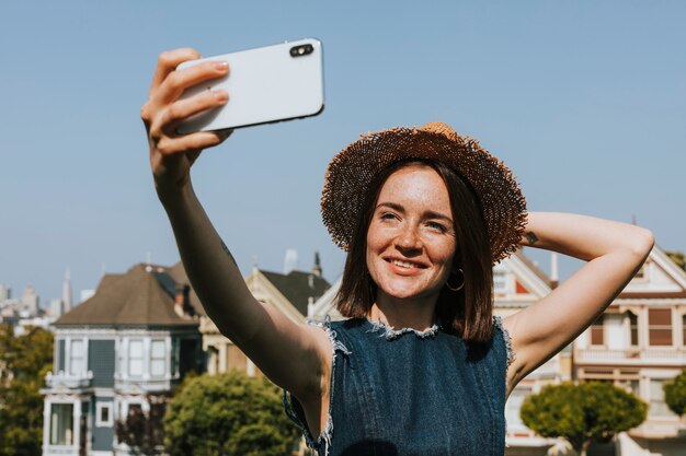 Donna che cattura un selfie con Painted Ladies of San Francisco, USA