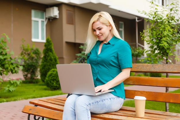 donna che cerca lavoro con un laptop in un parco urbano in estate