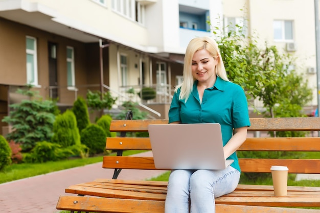 donna che cerca lavoro con un laptop in un parco urbano in estate