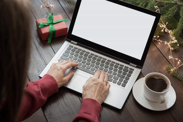 Donna che cerca o che compera dal computer portatile. Pianificare le vacanze.