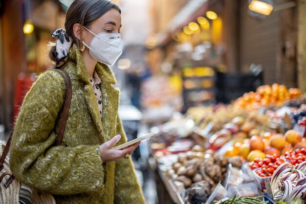 Donna che compra cibo sul mercato di strada durante la pandemia