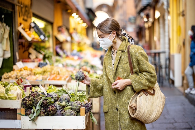 Donna che compra cibo sul mercato di strada durante la pandemia