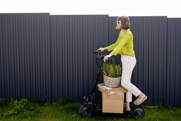 Donna che consegna merci in scooter elettrico