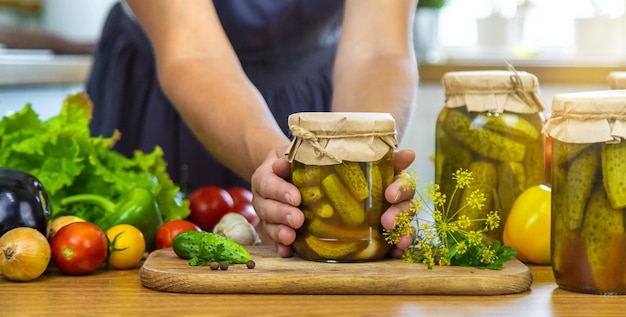 Donna che conserva verdure in barattoli in cucina Focalizzazione selettiva