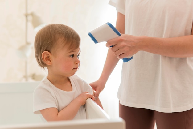 Donna che controlla la temperatura del bambino