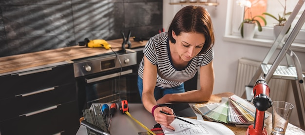 Donna che controlla modello alla nuova cucina