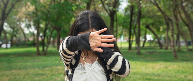 Donna che copre il viso e fa il segnale di stop