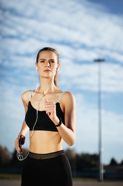 donna che corre all'aperto con le cuffie