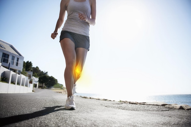 Donna che corre e raggi x al ginocchio per allenamento con infortunio o incidente sportivo durante l'esercizio o corsa in città