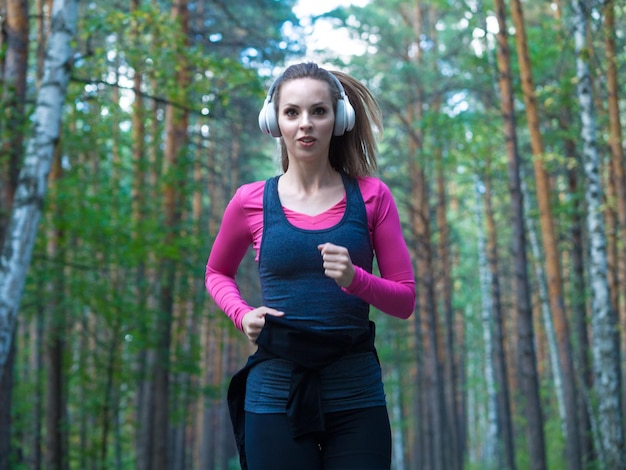 Donna che corre nel concetto di stile di vita sano fitness foresta boscosa