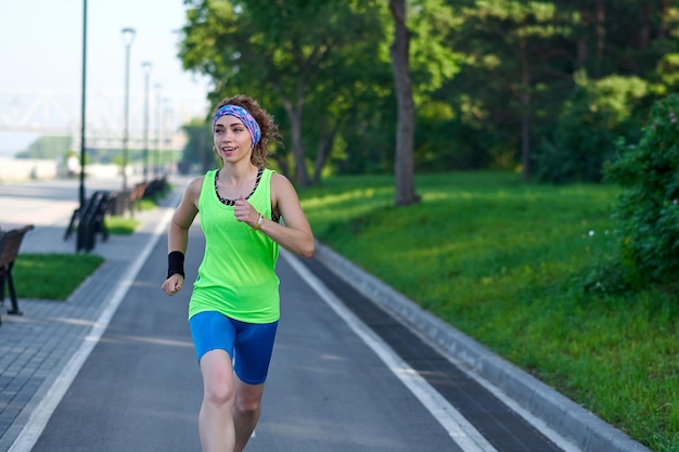 Donna che corre su pista durante la sessione di allenamento Corridore femminile che si esercita su pista di atletica