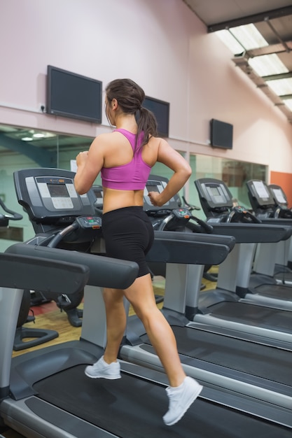 Donna che corre su un tapis roulant in palestra