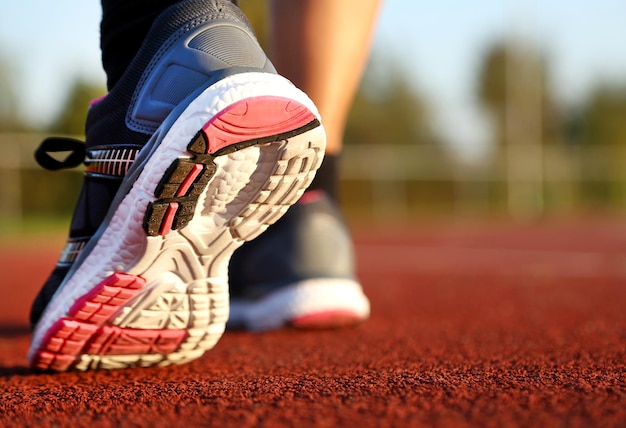 Donna che corre sulla pista di atletica al pomeriggio